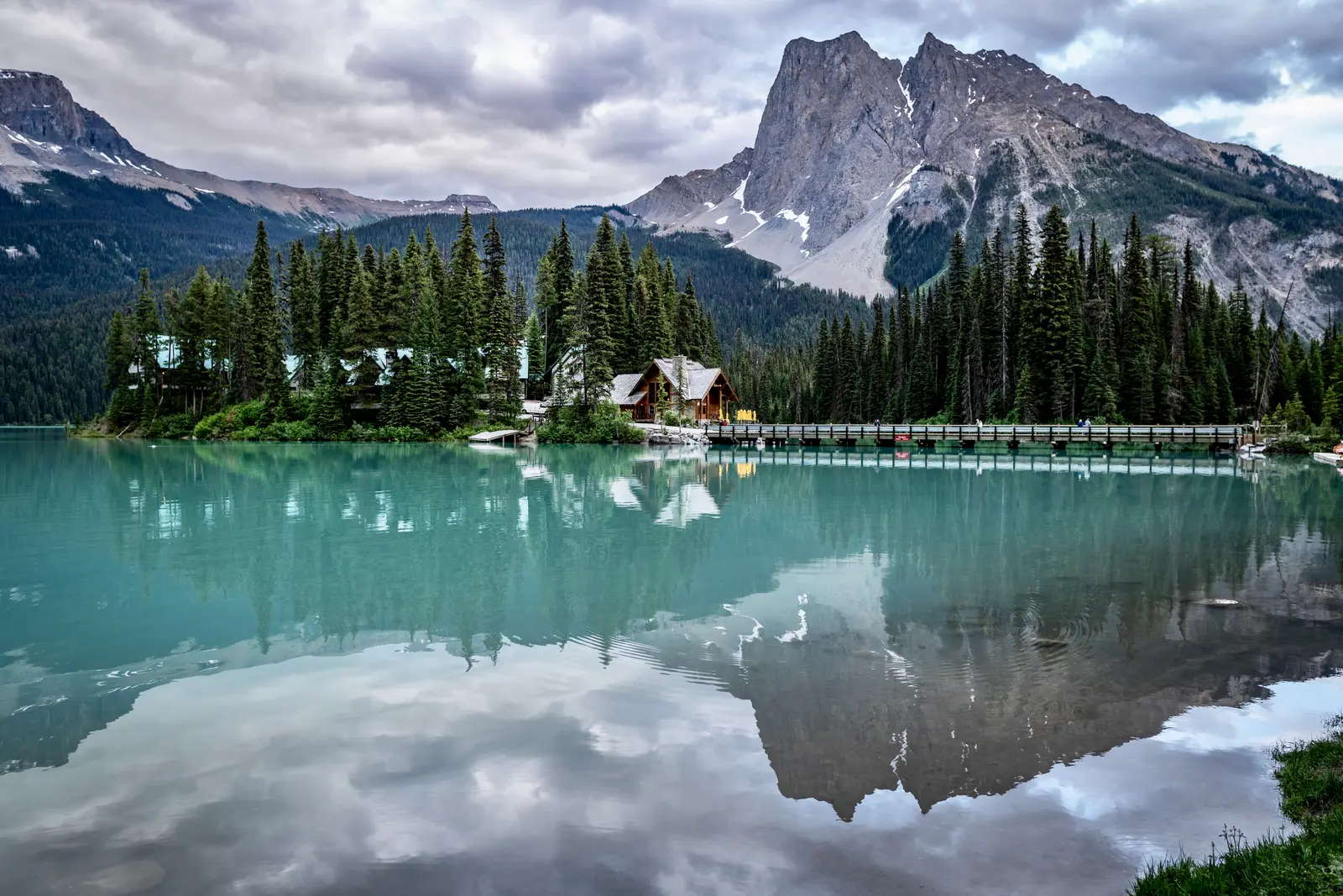 Emerald Lake below forested mountain slopes on a cool, rainy morning.