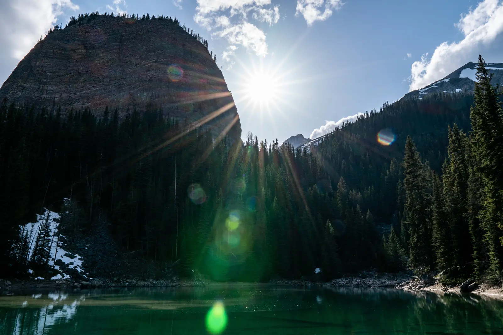 Mirror Lake in deep shade with sunlight over the surrounding cliffs.