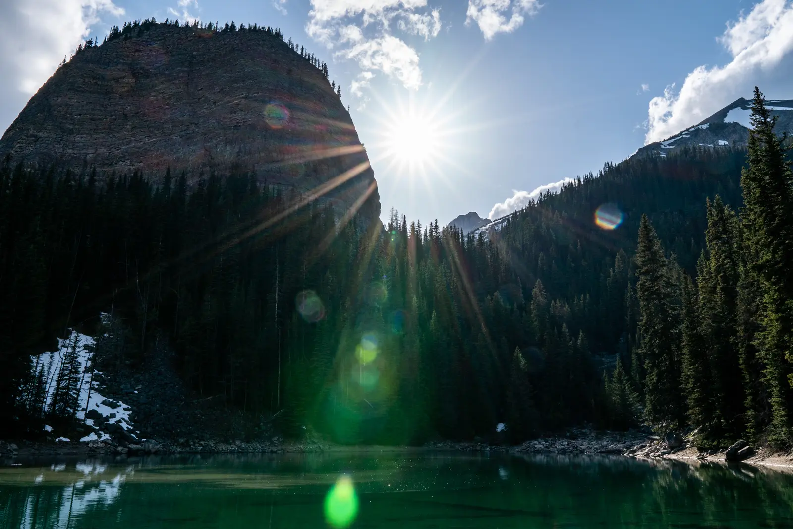 Mirror Lake in deep shade with sunlight over the surrounding cliffs.